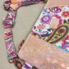 Stunning "Just Peachy" Sunshine Crossbody Crossbody. Measures 10 1/2" wise x 8" tall and 3" deep. $85.00 Colorful paisley floral fabric center, with striking holographic peach glitter vinyl. Rose gold hardware really ins striking in this combination. The exterior back also has a sipper pocket with rose gold zipper teeth and zipper pull. Matching adjustable strap in paisley and can be worn as a side strap or crossbody. Interior is waterproof canvas in rose gold color. It as a roomy slip pocket and zipper pocket.