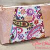Stunning "Just Peachy" Sunshine Crossbody Crossbody. Measures 10 1/2" wise x 8" tall and 3" deep. $85.00 Colorful paisley floral fabric center, with striking holographic peach glitter vinyl. Rose gold hardware really ins striking in this combination. The exterior back also has a sipper pocket with rose gold zipper teeth and zipper pull. Matching adjustable strap in paisley and can be worn as a side strap or crossbody. Interior is waterproof canvas in rose gold color. It as a roomy slip pocket and zipper pocket.