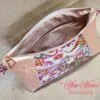 Stunning "Just Peachy" Sunshine Crossbody Crossbody. Measures 10 1/2" wise x 8" tall and 3" deep. $85.00 Colorful paisley floral fabric center, with striking holographic peach glitter vinyl. Rose gold hardware really ins striking in this combination. The exterior back also has a sipper pocket with rose gold zipper teeth and zipper pull. Matching adjustable strap in paisley and can be worn as a side strap or crossbody. Interior is waterproof canvas in rose gold color. It as a roomy slip pocket and zipper pocket.