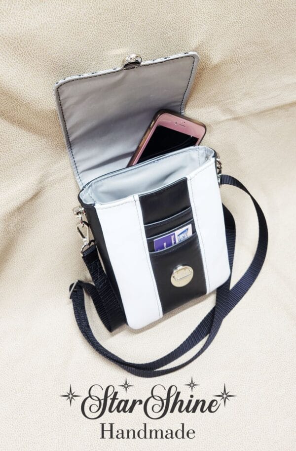 Black and White Snow Leopard Mini Mallory Crossbody. Upper Front View Showing interior with hidden cell phone pocket.